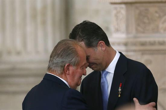El Rey Juan Carlos abraza al Príncipe de Asturias, Felipe de Borbón, tras firmar la ley orgánica que hará efectiva a medianoche su abdicación, en una 