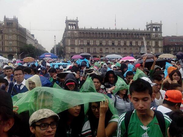 Aficionados resisten la lluvia y continúan en el Zócalo viendo el partido del Tri ante Croacia.