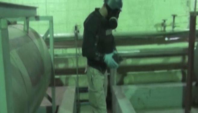 En esta imagen de un programa de la televisión siria puede verse trabajando a un inspector de la OPAQ 