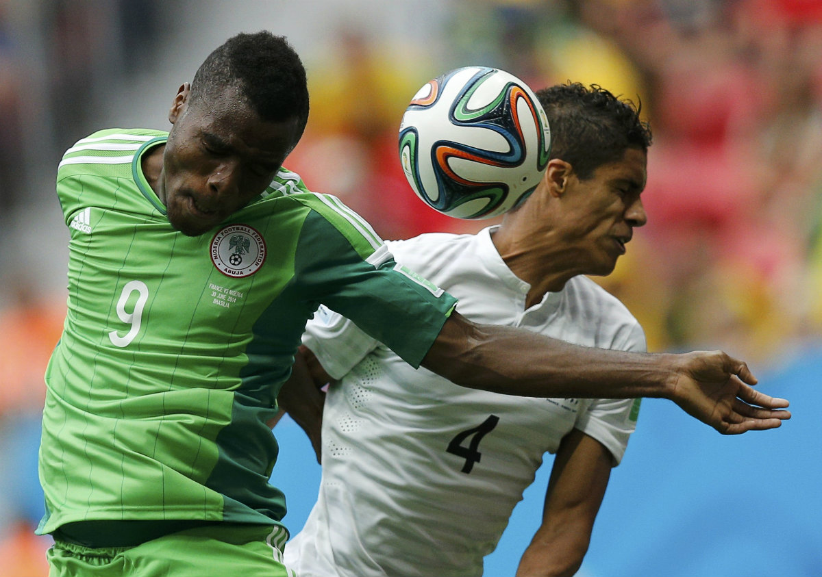  Raphael Varane peleando el esférico con Emmanuel Emenike