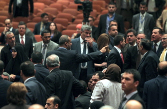 El legislador chiita Kadhim al-Sayadi, del bloque del primer ministro Nuri al Maliki, señala con un dedo a los diputados kurdos con los que discute