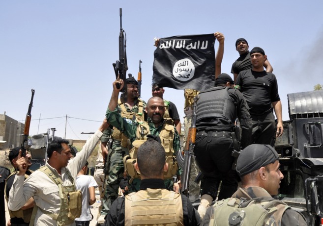 Fuerzas de seguridad iraquíes despliegan una bandera del ISIS durante una patrulla en Dalli Abas