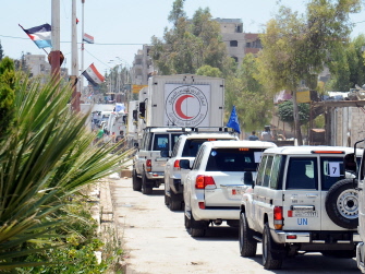 Un convoy humanitario de la Media Luna Roja transporta un cargamento de comida de Naciones Unidas a un barrio de Damasco