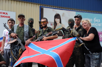 Militantes prorrusos de Ucrania posan con la nueva bandera prorrusa en Donetsk