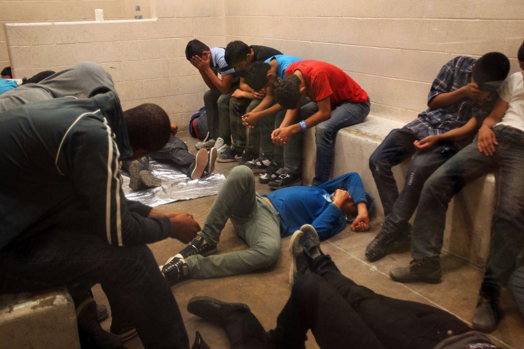 Migrantes que fueron sorprendidos cruzando la frontera de manera ilegal se encuentran dentro de la estación de la Patrulla Fronteriza de McAllen, en T