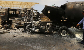 Los restos de un camión y un avión, destruidos por el fuego de los combates, en el aeropuerto de Trípoli
