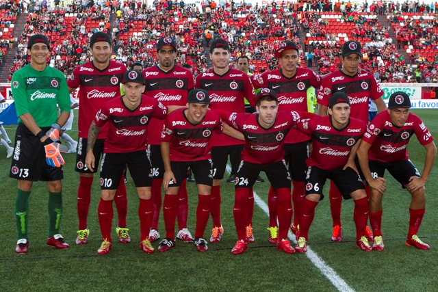 Los jugadores de Xolos posando con gorras