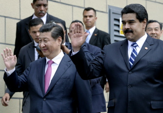 El presidente de Venezuela, Nicolas Maduro (d) y el presidente de China, Xi Jinping (i), saludan a la multitud, hoy en Caracas