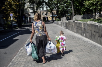 Una mujer camina con bolsas con provisiones suministradas en un edificio ocupado por separatistas prorrusos en Donetsk