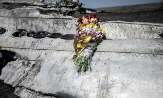 Flores dejadas por los padres de una mujer australiana fallecida en el avionazo, en un resto del avión, junto a Grabovo