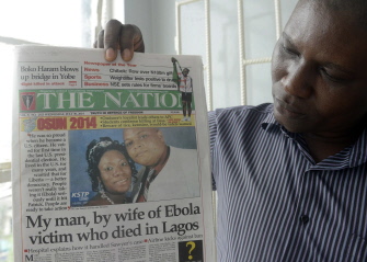 Un hombre muestra la portada de un diario con la historia del diplomático liberiano Patrick Sawyer, muerto a causa del Ebola en Lagos, Nigeria