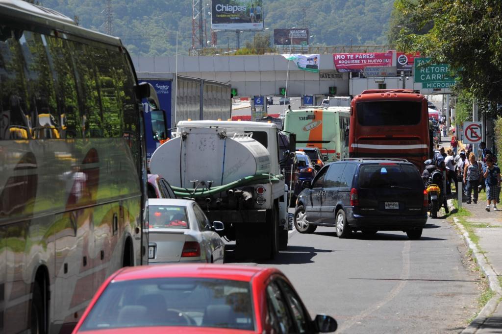 Largas filas de vehículos en la caseta de la carretera México-Cuernavaca por el nuevo sistema de pago.