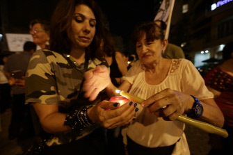 Mujeres libanesas encienden velas para recordar a los soldados caídos en los recientes choques con yihadistas, en Beirut 