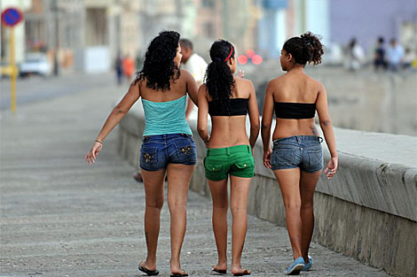 Tres jóvenes cubanas pasean por el Malecón de La Habana