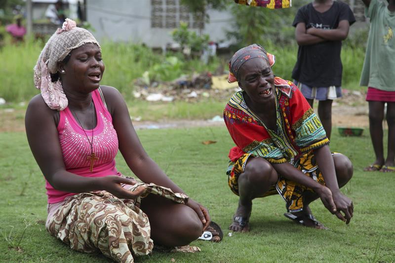 Un grupo de mujeres llora durante el entierro de víctimas del virus Ébola, en la comunidad de Banjor, a las auferas de Monrovia, Liberia