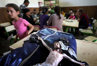 Un crucifijo aparece en el bolso de un cristiano iraquí que huyó de Qaraqush, en la iglesia de San José en la ciudad kurda de Erbil