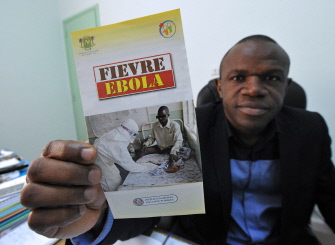 Coulibaly Daouda, jefe del departamento epidemiológico del Instituto Nacional de Salud en Costa de Marfil, enseña un panfleto sobre el ébola