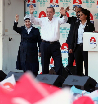Erdogan (d) saluda a sus simpatizantes junto a su mujer, Emine (i) durante un acto electoral hoy en Ankara