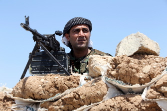 Un combatiente kurdo, conocido como "peshmerga", toma posición en la línea del frente en Bashiqa, trece kilómetros al noreste de Mosul