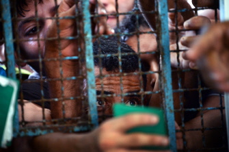 Palestinos muestran sus tarjetas de identificación para poder recibir comida en un centro de la ONU en Gaza