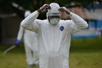 Un enfermero se quita sus ropas protectoras durante un ejercicio de simulación de un caso de ébola en Biankouma, Costa de Marfil