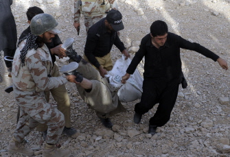 Agentes de seguridad paquistaníes retiran el cadáver de un terrorista tras un ataque en una base aérea en Quetta