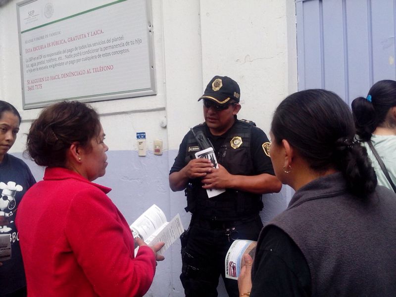 Policías dialogaron con varios padres de familia afuera de la primaria donde el miércoles un niño fue expulsado por presunto acoso escolar.