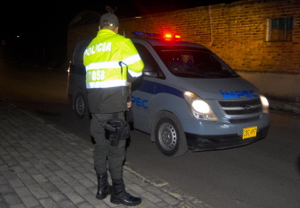 Un oficial de policía colombiano hace guardia en la entrada de la prisión de Cómbita mientras Popeye la abandona en un vehículo