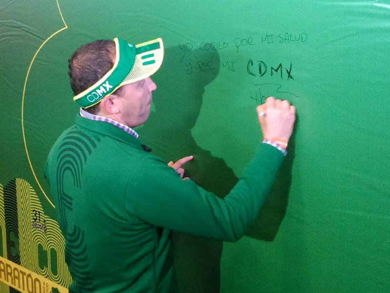 Horacio de la Vega director del Instituto del Deporte firmando la pared alusiva al Maratón 