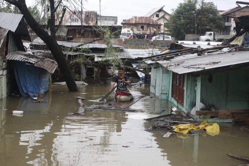 Un hombre de Cachemira avanza entre algunas casas después de las inundaciones.