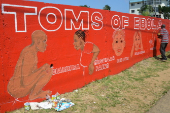 Stephen Doe, artista callejero liberiano, pinta en un mural para informar a la gente sobre los síntomas del ébola, en una calle de Monrovia