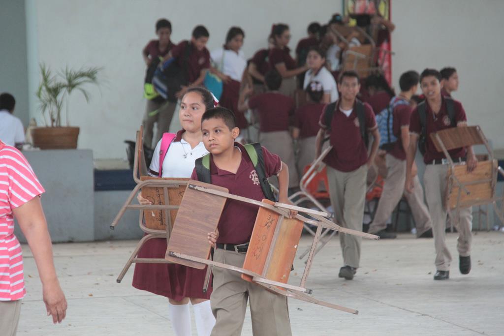 Cargando sus pupitres, los alumnos desalojaron los salones de clases.