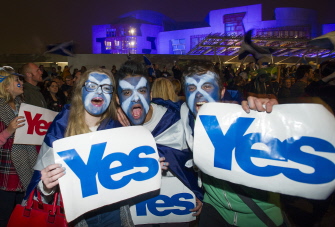 Partidarios de la independencia de Escocia muestran hoy carteles con el "Yes" (Sí) ante el parlamento escocés, en Edimburgo