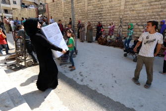 Una mujer lleva cajas de alimentos para familias que huyeron de la ciudad siria kurda de Ain al-Arab (Kobane para los kurdos) en Alepo 