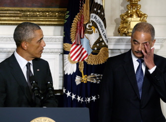 Holder se limpia una lágrima de emoción mientras escucha la intervención de Obama en su despedida