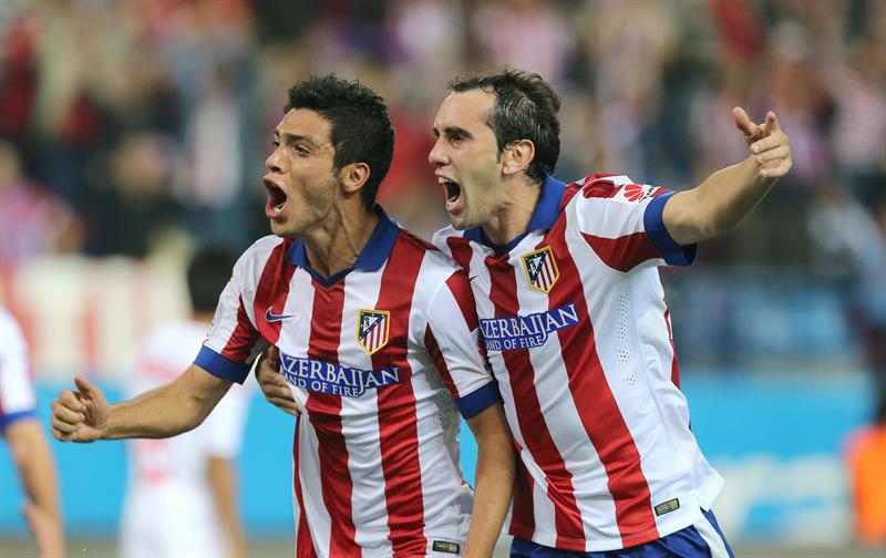 Jiménez y Diego Godín celebran gol del mexicano 
