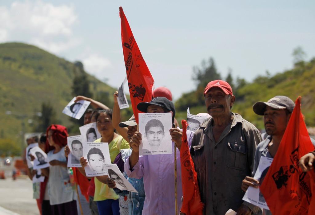 Padres de los estudiantes desaparecidos participaron en la manifestación y mostraron fotografías de sus hijos para localizarlos.