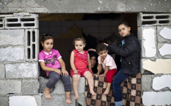 Niños palestinos, sentados en una ventana de un edficio parcialmente destruido en Al Tufah, al este de la ciudad de Gaza