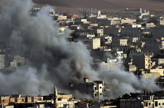 Humo proveniente de un edificio golpeado por un ataque aéreo de la coalición internacional asciende en Kobane