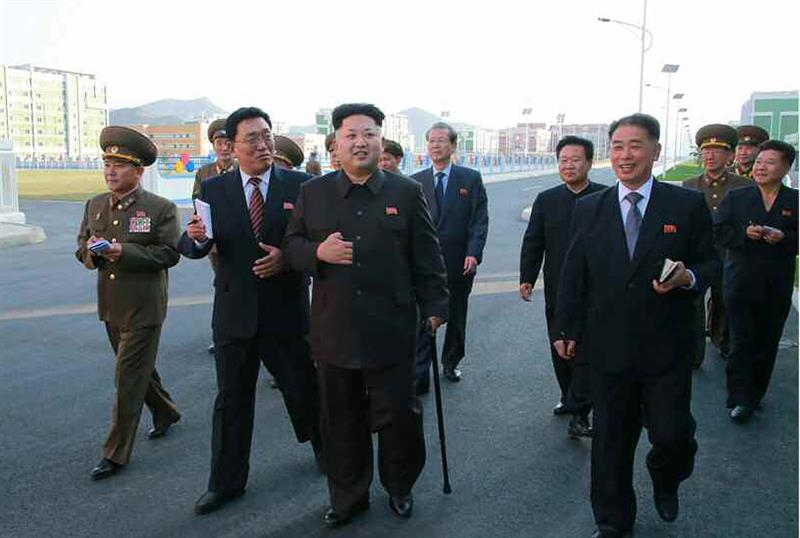 Kim Jong-un (c) camina apoyado en un bastón durante su visita al distrito residencial científico Wisong, en Pyongyang 