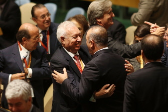 El canciller español, José Manuel García-Margallo (i) se abraza a su par turco, Mevlut Cavusoglu, tras la votación en la Asamblea General