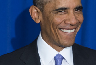 Obama sonríe antes de firmar hoy una orden ejecutiva para hacer más seguro el sistema federal de pagos