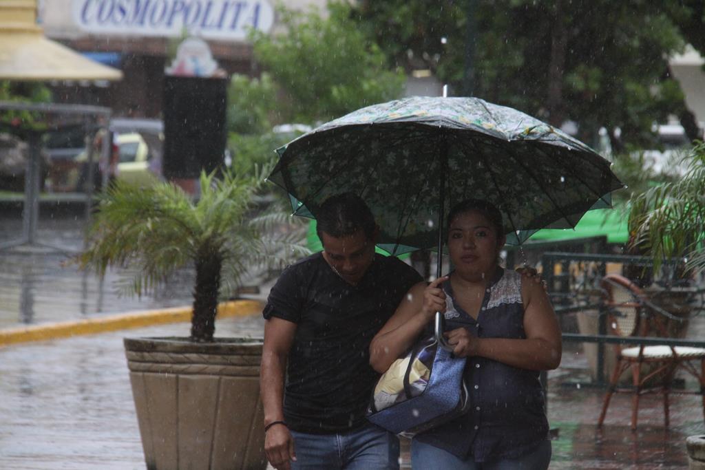 Las sombrillas no fueron de mucha ayuda ya que la lluvia se registró con gran fuerza