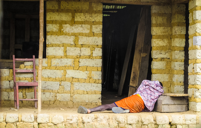 Un hombre que sufre de ébola se encuentra en el suelo afuera de una casa en Port Loko, en las afueras de Freetown.