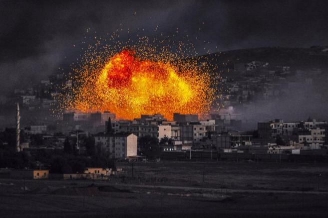 El humo y las llamas se elevan después de una explosión durante los combates por la noche en la ciudad de Kobane