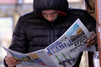 Un hombre lee un periódico con los resultados de los comicios ucranianos, en Kiev