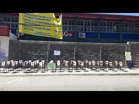 Los estudaintes en plena calle colocaron 43 pupitres con el retrato de los normalistas desaparecidos y en la pared una pancarta que resume el sentir d