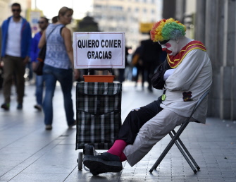 Rayito, un mendigo disfrazado como un payaso, mide limosna en la Gran Vía, en el centro de Madrid 