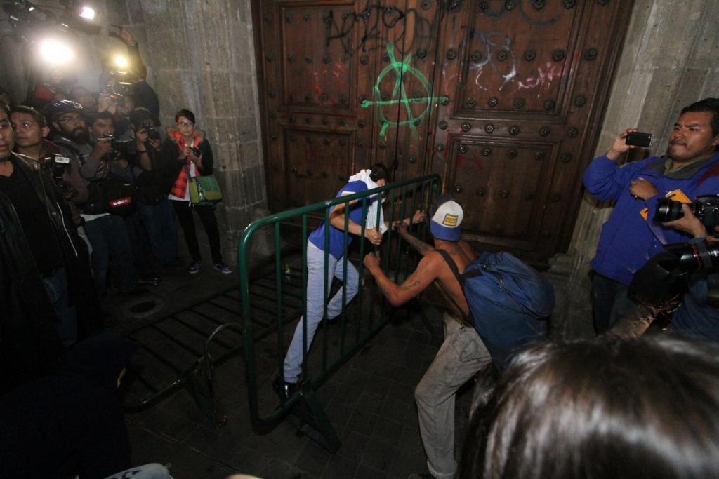 Algunos jóvenes tomaron una de las vallas metálicas que resguardaba el edificio para golpear la puerta principal e intentar ingresar.