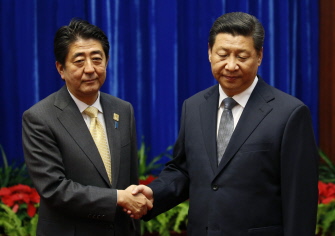 El presidente de China, Xi Jinping (d), saluda al primer ministro de Japón, Shinzo Abe, en el Gran Salón del Pueblo, en Pekín